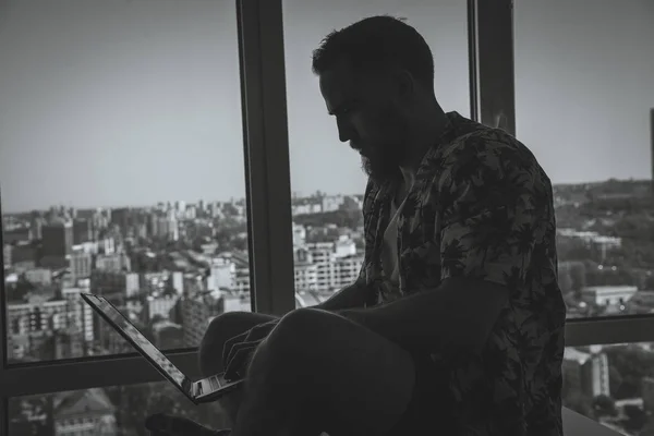 Um tipo com barba a trabalhar num portátil em casa. — Fotografia de Stock