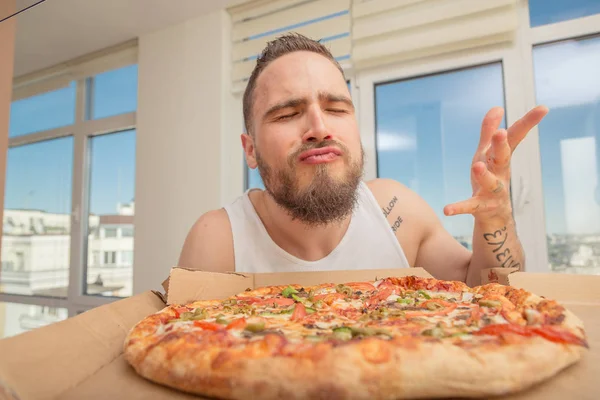 Pizzu. Chlap s plnovousem jí pizza — Stock fotografie