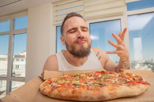 Pizza. Un ragazzo con la barba mangia la pizza — Foto Stock