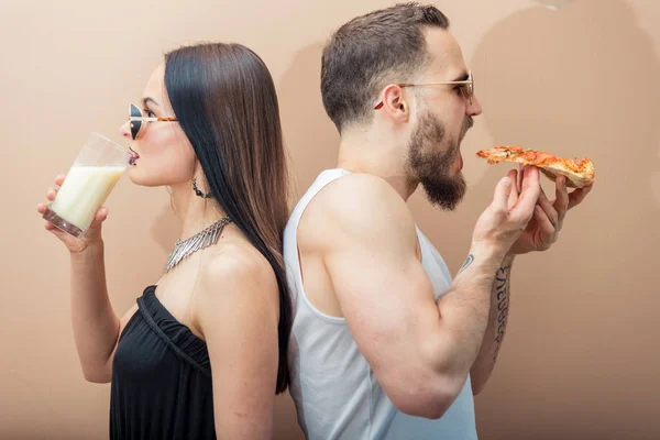 Una chica bebe leche, y un chico come pizza — Foto de Stock