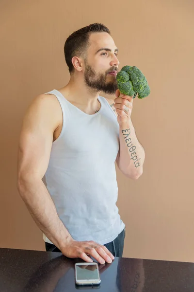 Un tipo con barba huele brócoli — Foto de Stock