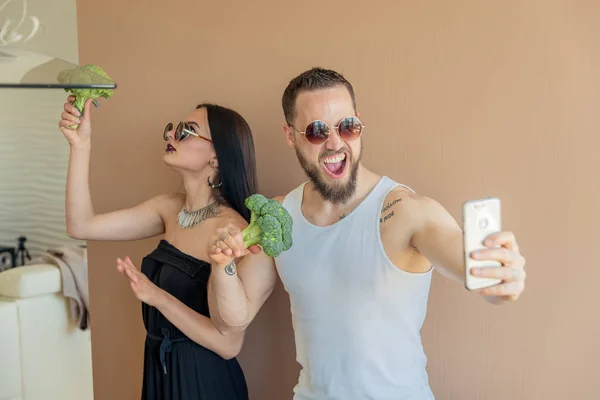 Un chico y una chica con brócoli hacen selfies — Foto de Stock