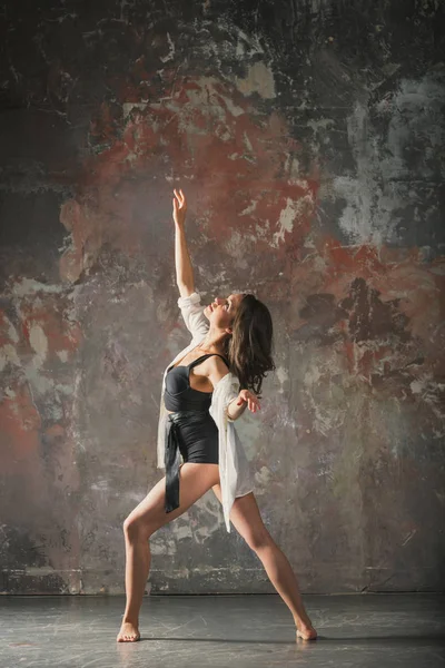 Chica bailando sobre un fondo de pared gris — Foto de Stock