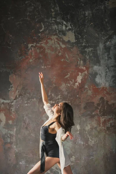 Fille danse sur un fond de mur gris — Photo