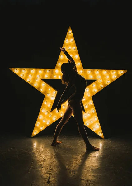 A menina está dançando contra o pano de fundo de uma estrela brilhante — Fotografia de Stock
