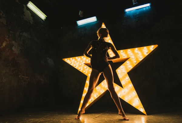 La chica está bailando sobre el telón de fondo de una estrella brillante —  Fotos de Stock