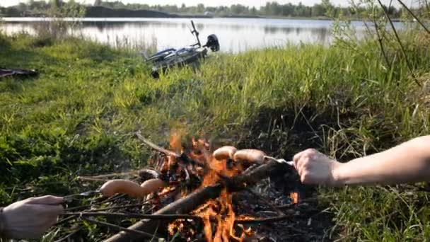 Picknick in der Natur. auf dem Scheiterhaufen braten Würstchen — Stockvideo