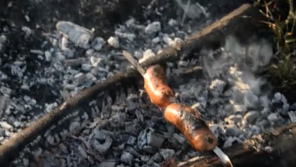 Pique-nique dans la nature. Sur le bûcher cuire les saucisses 