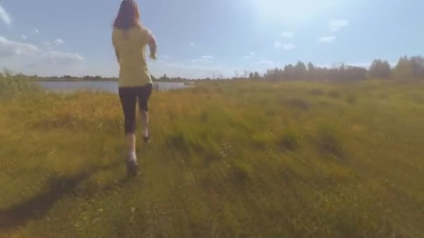La chica está corriendo a través del campo — Vídeo de stock