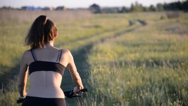 Девушка на горном велосипеде в поле — стоковое видео
