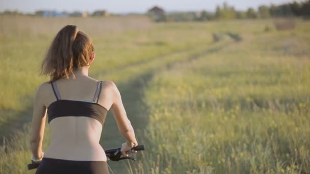 Mädchen mit Mountainbike im Feld — Stockvideo