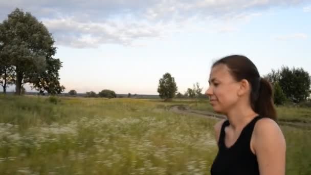 Het meisje loopt langs het veld — Stockvideo