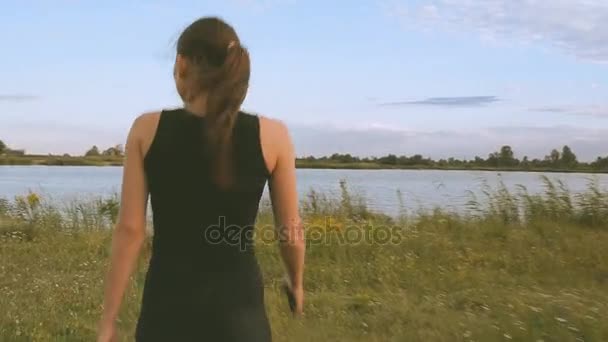 La ragazza sta camminando lungo il campo — Video Stock