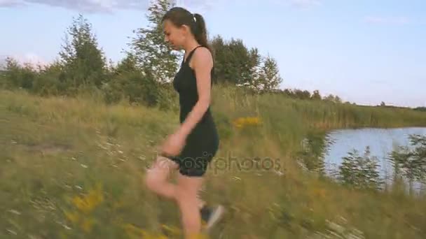 La ragazza sta camminando lungo il campo — Video Stock