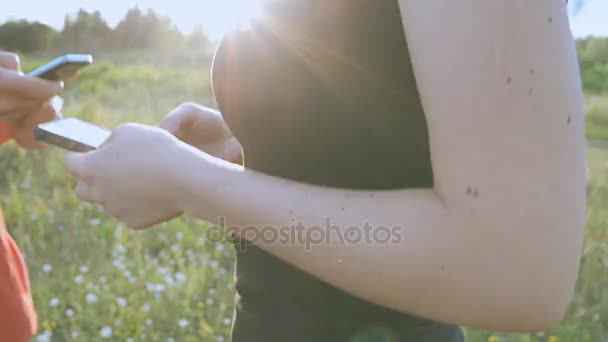 Meisje en jongen in de natuur op zoek in een mobiele telefoon — Stockvideo