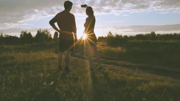 Tjej och kille i naturen inne i en mobiltelefon — Stockvideo