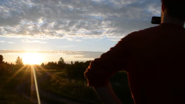 Tjej och kille i naturen inne i en mobiltelefon — Stockvideo