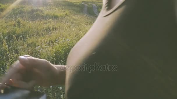 Дівчина і хлопець в природі дивиться на мобільний телефон — стокове відео