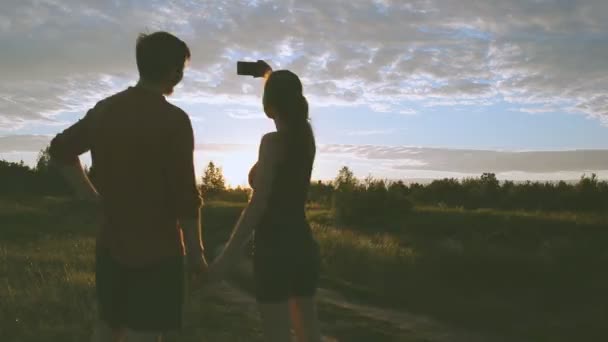 Mädchen und Mann in der Natur schauen in ein Handy — Stockvideo