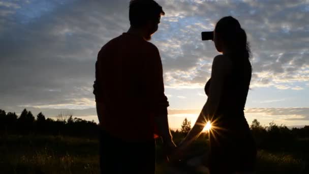 Meisje en jongen in de natuur op zoek in een mobiele telefoon — Stockvideo