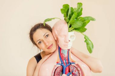 Bir yoga koçu tıbbi manken yanında oturur