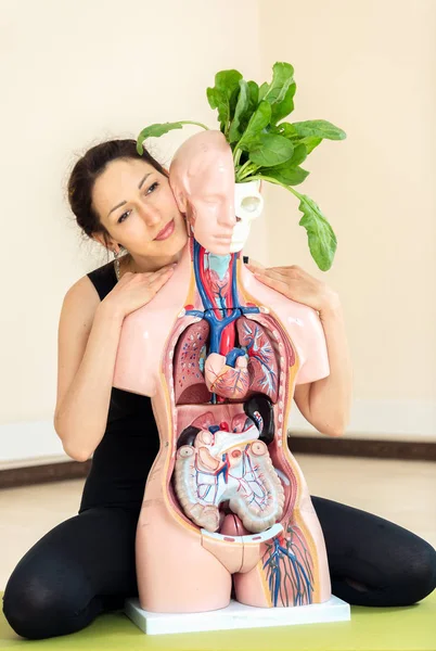 A yoga coach sits next to a medical dummy — Stock Photo, Image