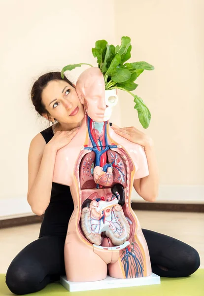 Um treinador de ioga senta-se ao lado de um manequim médico — Fotografia de Stock