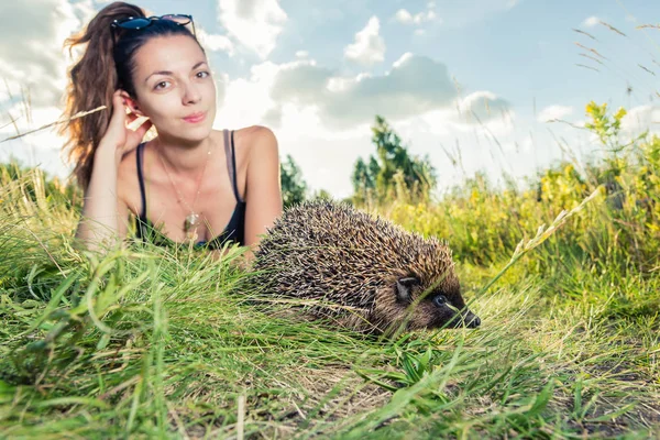 A girl strokes on the nature of a hedgehog — Stock Photo, Image