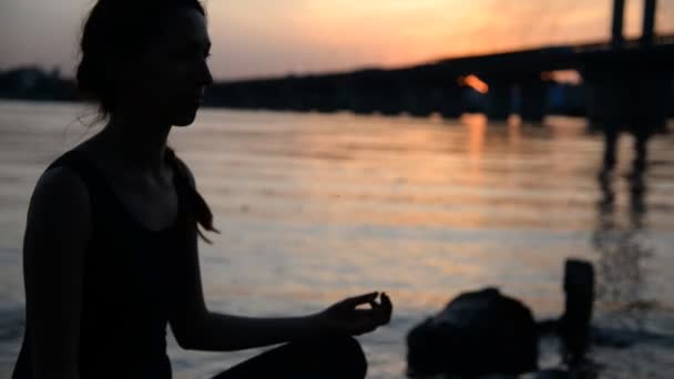 Flicka som utövar yoga på bakgrunden av staden — Stockvideo