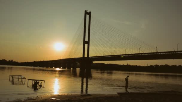 Ποτάμι και γέφυρα. Οι περισσότεροι στο ηλιοβασίλεμα — Αρχείο Βίντεο