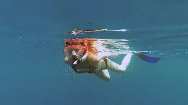 Snorkeling. Bir kız bir maske ve tüp denizde yüzen