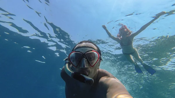 Snorkeling. Bir kız bir adamla bir maske ile denizde yüzüyor — Stok fotoğraf