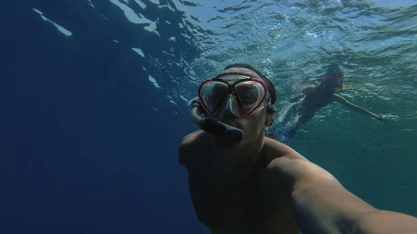 Snorkeling. Un tipo con una chica está nadando en el mar con una máscara — Foto de Stock
