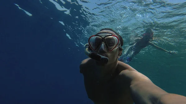 Snorkeling. Un ragazzo con una ragazza sta nuotando nel mare con una maschera — Foto Stock