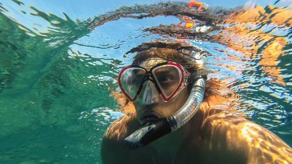 Snorkelen. De man in het masker en de buis drijft in de zee — Stockfoto