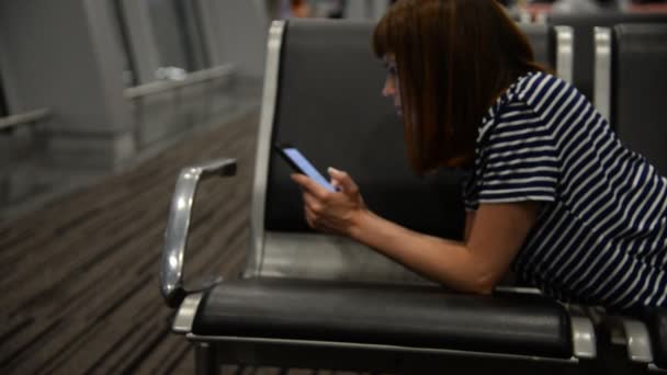 Una ragazza sta aspettando un aereo all'aeroporto — Video Stock