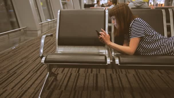 Uma menina está esperando por um avião no aeroporto — Vídeo de Stock