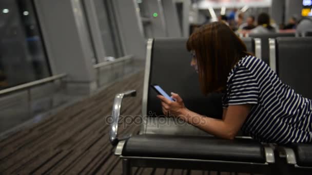 Uma menina está esperando por um avião no aeroporto — Vídeo de Stock