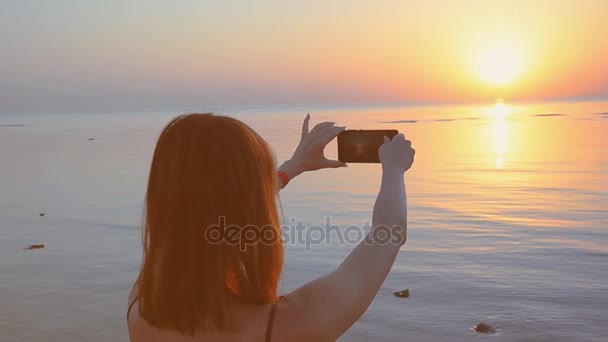 Dívka je při západu slunce na mobilní telefon — Stock video