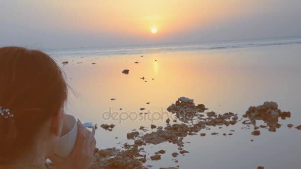 Une fille boit du café sur le fond de la mer — Video