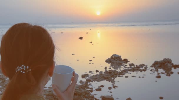 여자는 바다의 배경에 커피 음료 — 비디오