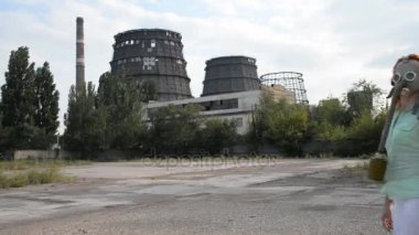 Küresel ısınma. Bir gaz maskesi bir fabrika arka plan üzerinde bir kız