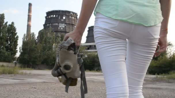 Opwarming van de aarde. Een meisje in een gasmasker op de achtergrond van een fabriek — Stockvideo