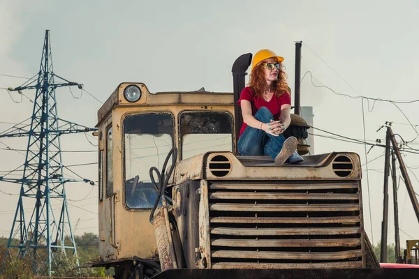 La femme est ingénieure. Une femme repose sur un tracteur . — Photo