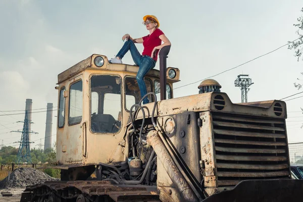 La mujer es ingeniera. Una mujer descansa sobre un tractor . —  Fotos de Stock