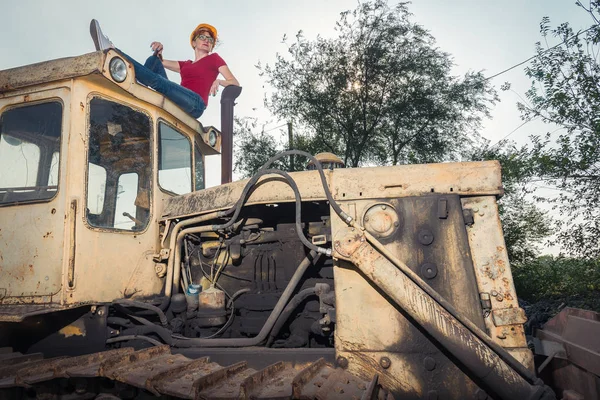 A mulher é engenheira. Uma mulher está descansando em um trator . — Fotografia de Stock