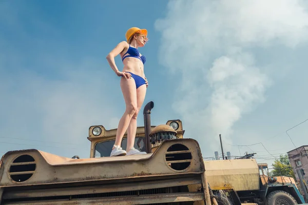 El calentamiento global. Una chica en traje de baño tomando el sol en un tractor . — Foto de Stock