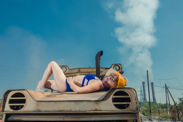 El calentamiento global. Una chica en traje de baño tomando el sol en un tractor . —  Fotos de Stock