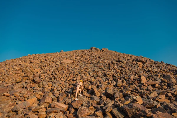 Minerale rosso. Montagne di minerale rosso. Una ragazza in costume da bagno si trova su un re — Foto Stock