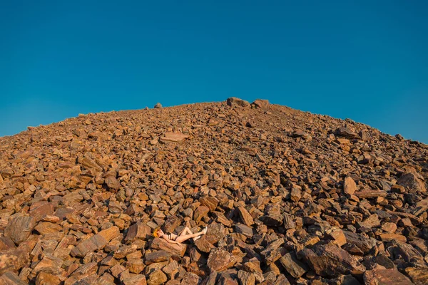 赤い鉱石。赤い鉱石の山。水着姿の女の子が re にあります。 — ストック写真